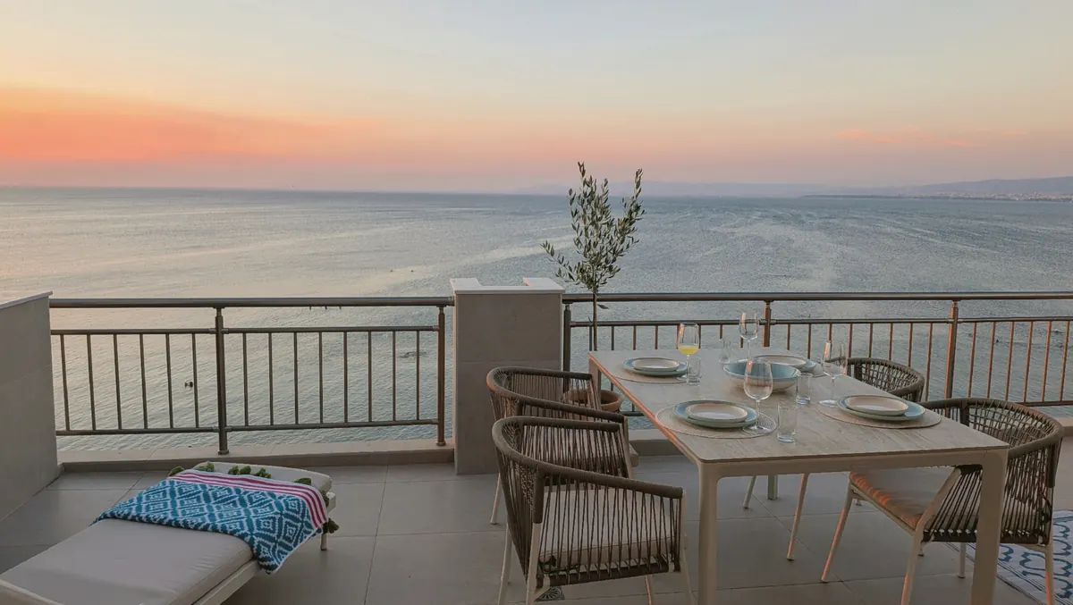 Sun setting into the sea behind the terrace dining table